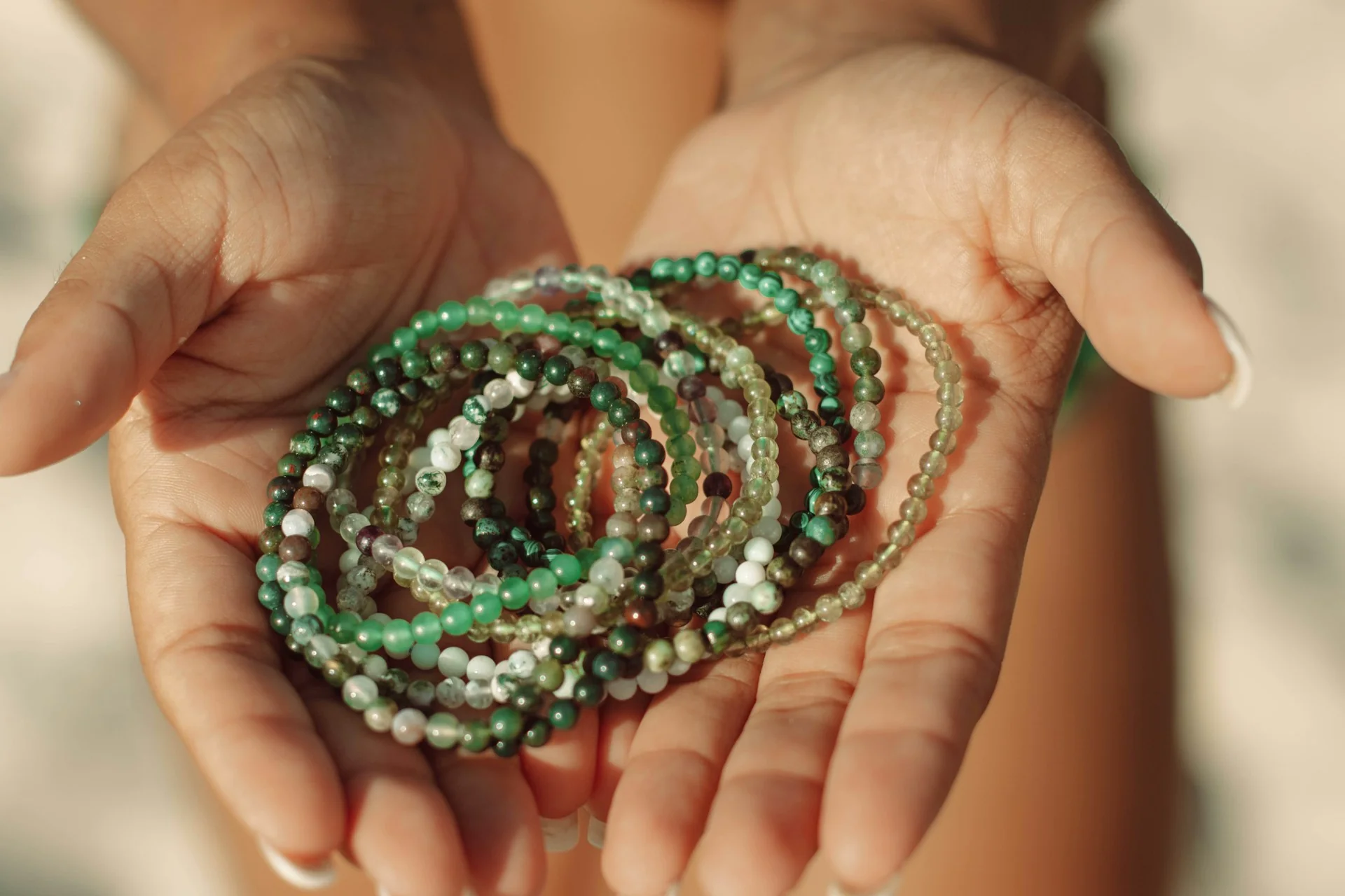 lots of jade jewelry in the palm of a person